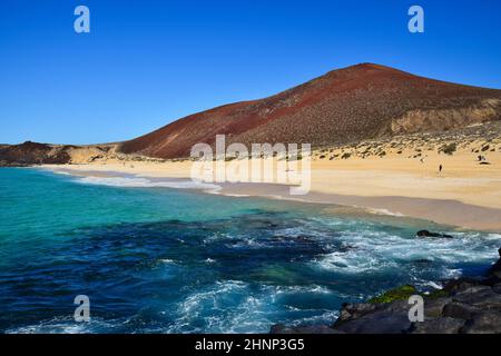 Schöner Playa de las Conchas mit Montana Bermeja im Hintergrund. Die Insel La Graciosa, die zu Lanzarote, Kanarische Inseln, Spanien gehört. Stockfoto