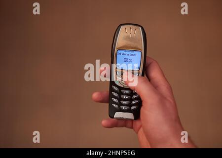 Einrichten eines Frühalarms auf einem alten Mobiltelefon Stockfoto