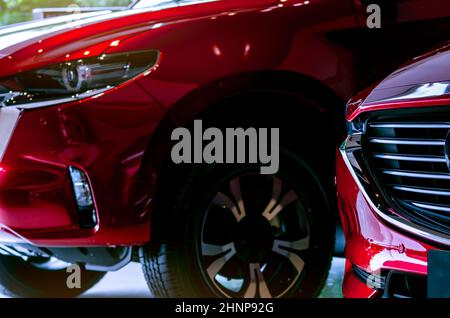 Nahaufnahme rotes Auto in Luxus-Showroom geparkt. Autohaus. Neues Auto in modernem Showroom geparkt. Auto für Verkauf und Vermietung Geschäft. Auto-Leasing. Verkaufsförderung und Marketingkonzept für Automobile. Stockfoto