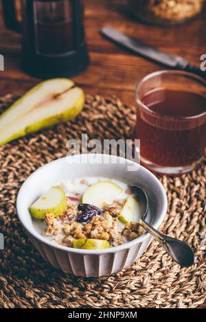 Hausgemachtes Müsli mit frischem Birnen und Milch in Vintage Bowl Stockfoto