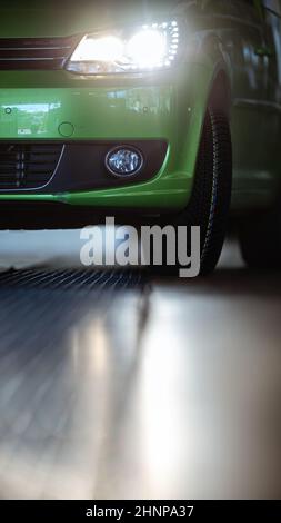 Auto in einer Garage für Wartung, Öl, Reifenwechsel (flaches, farblich getöntes Bild des Freiheitsgrads) Stockfoto
