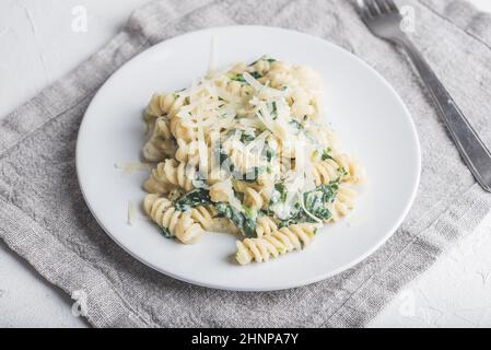 Cremiger Spinat Fusilli Pasta mit Ricotta und Parmesan auf Weiß Platte Stockfoto