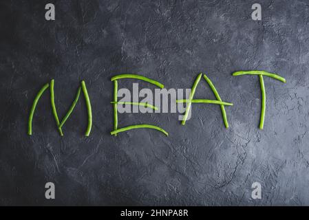 Wort Fleisch in frischen Pods of Green Beans geschrieben Auf dunklem Beton-Hintergrund Stockfoto