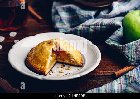 Hausgemachter Apfel Mini Pie auf weißem Teller mit Tasse Schwarzer Tee Stockfoto