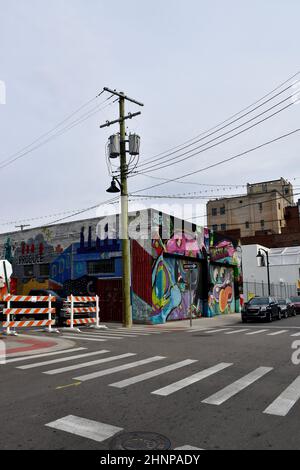 Ein Eckgebäude mit einem Wandgemälde von 2016 links von Jesse Kassel und rechts von den Graffiti-Künstlern Ghost Beard und Patch Whiskey in Detroit, Michigan, USA. Stockfoto