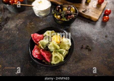 Flach Lay Zusammensetzung der Schüssel mit Knödeln, Glas saurer Creme auf Holzbrett für Design-Zwecke Stockfoto