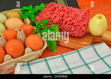 Blatt vor den Mund. Hackfleisch mit Zutaten zum Kochen. Gemischtes Hackfleisch, Burger bereit, Fettsäuren, meaetballs. Food-fotografie. Kulinarische Konzept. Hackfleisch Rezept Stockfoto