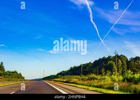 Cross from Clouds Flugzeuge Chemtrails am Himmel, Autobahn, Schweden. Stockfoto