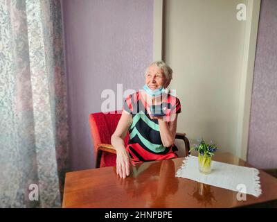 Happy 70s Großmutter halten Smartphone aufzeichnen Audio-Nachricht sprechen auf Gadget zu Hause Stockfoto