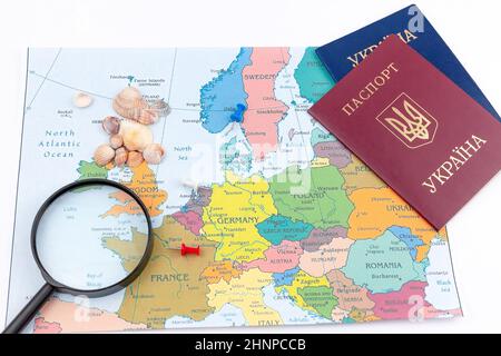 Reisearrangement mit Dollar, Euro, zwei Pässen und Lupe auf einem Kartenhintergrund. Reisekonzept. Stockfoto