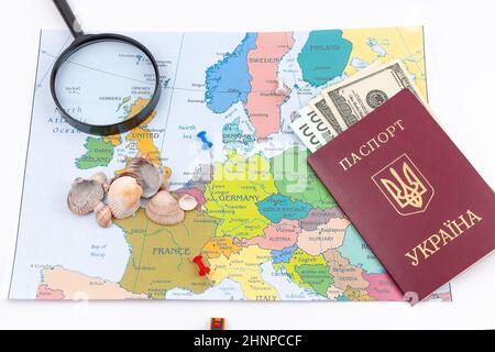 Reisearrangement mit Dollar, Euro, zwei Pässen und Lupe auf einem Kartenhintergrund. Reisekonzept. Stockfoto