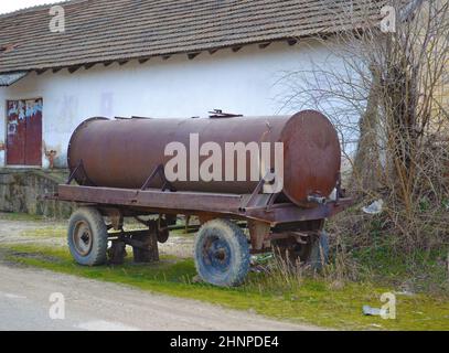 In der Nähe der Straße parkte ein alter verrosteter Wasserbehälter Stockfoto