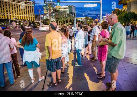 Fußgänger warten am Strip in Las Vegas auf grünes Licht, um die Straße zu überqueren. Stockfoto