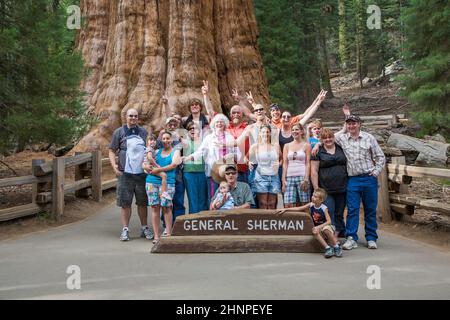 Glückliche Familie genießt posiert im Sequoia Nationalpark in fromt von General sherman Sequoia Baum Stockfoto