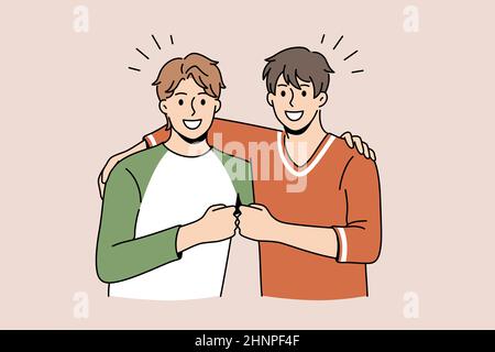 Freundschaft und positive Emotionen Konzept. Zwei junge lächelnde glückliche Männer stehen mit den Fäusten zusammen als Symbol für Einheit und Freundschaft Stockfoto