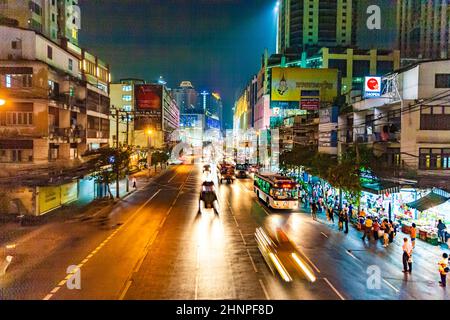 Blick über die Skyline von Bangkok mit der Hauptstraße sukhumvit bei Nacht, die Büroblöcke und verschwommene Autos bei Nacht zeigt Stockfoto
