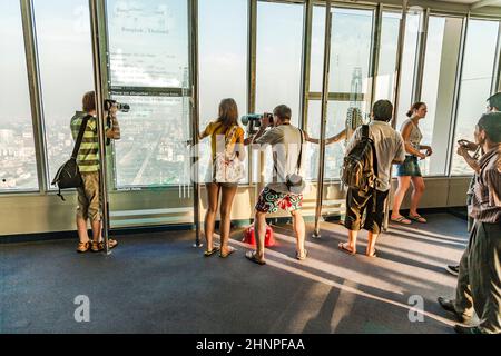 Die Menschen genießen den Blick auf die Skyline von Bangkok von der Plattform am Aussichtspunkt Mahanakhon Skywalk Stockfoto