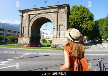 Tourismus in Italien. Rückansicht eines Touristen-Mädchens mit Blick auf den Augustusbogen in Aosta, Italien. Stockfoto