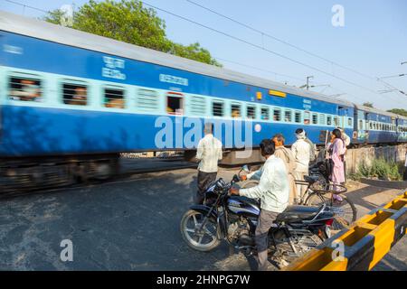 Die Menschen warten am Bahnübergang in der Nähe von Fatehpur Sikri, Indien. Stockfoto