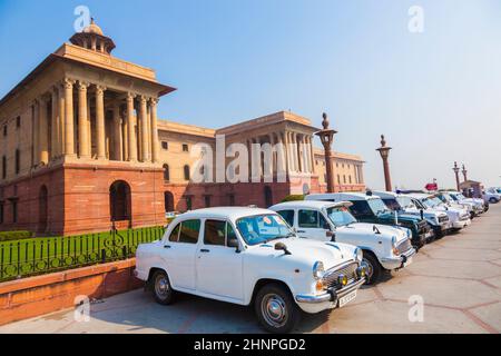 Offizielle Autos des Hindustan Ambassador parken vor dem North Block, dem Sekretariat Gebäude in Delhi, Indien Stockfoto