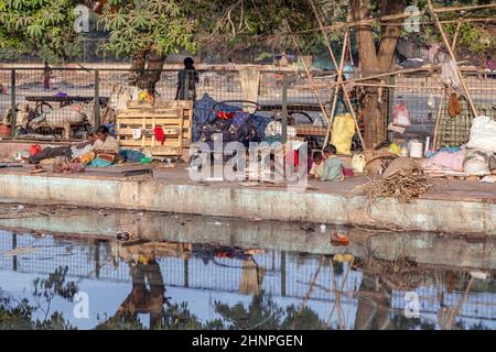 Arme Menschen leben an der Promenade eines Kanals in der Nähe des Meena Bazaar Market in Alt-Delhi, Indien. Stockfoto