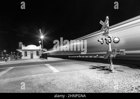 Der Zug fährt nachts am Bahnübergang Kingman vorbei. Stockfoto