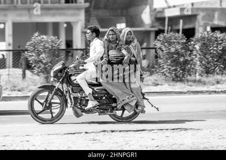 Mann mit Mutter und Frau, die auf dem Roller auf der Autobahn fahren Stockfoto