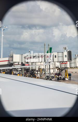 Blick durch das Flugzeugfenster zur Passagierbrücke des internationalen Flughafens von Miami Stockfoto