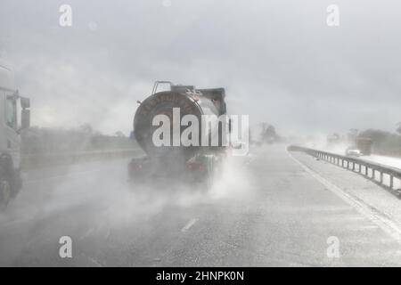 Autobahn fahren mit schlechter Sicht mit Regen und Straßenspray von Fahrzeugen vor der Fahrt in die Sonne - Großbritannien Stockfoto