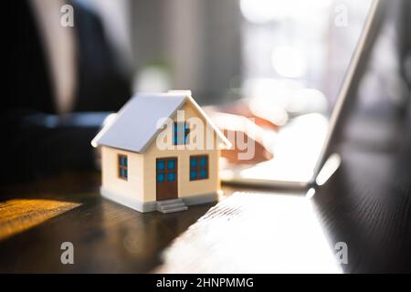 Suchen Immobilien-Haus Oder Haus Auf Laptop-Computer Stockfoto