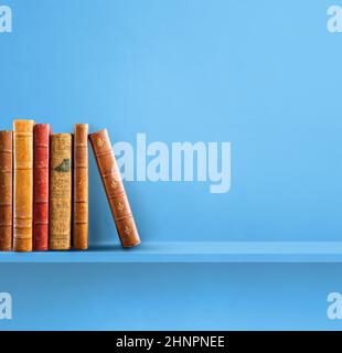 Reihe alter Bücher auf blauem Regal. Quadratischer Hintergrund Stockfoto