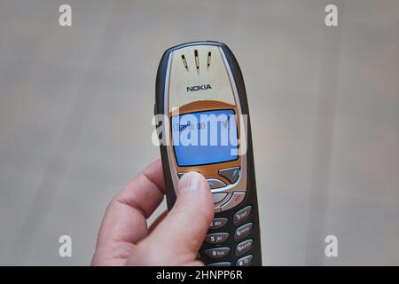 Einstellen des Alarms auf einem alten Mobiltelefon, dem Nokia 6310i Stockfoto