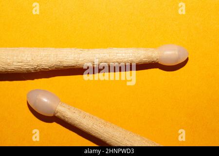 Paar Drumsticks auf gelbem Hintergrund Nahaufnahme. Kopierbereich Stockfoto