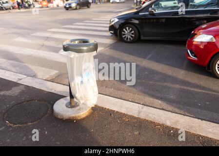 Müll auf dem Bürgersteig in Rom. Eine Stadturne in Rom aus einem Metallrand und einer transparenten Plastiktüte. Stockfoto