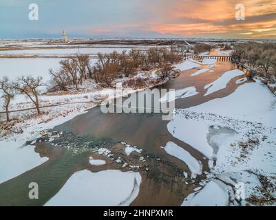 Sonnenuntergang über dem South Platte River mit einem Umweg-Damm und Ackerland auf den Ebenen von Colorado in der Nähe von Milliken, Luftaufnahme mit Winterlandschaft Stockfoto