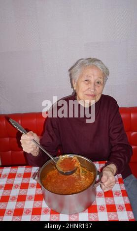 Ältere Frau, die in der Küche gesund kocht Stockfoto