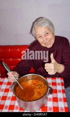 Ältere Frau, die in der Küche gesund kocht Stockfoto