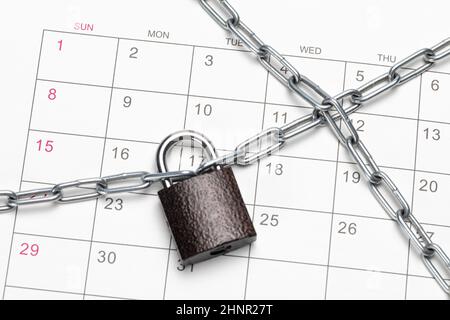 Der Kalender ist in eine Kette eingewickelt und verriegelt. Terminplanung oder -Sperre, Quarantänekonzept. Stockfoto