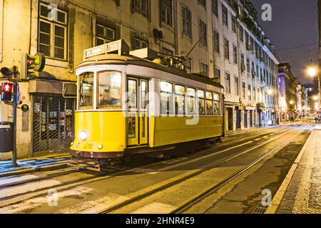 Traditionelle gelbe Straßenbahn in der Innenstadt von Lissabon bei Nacht Stockfoto