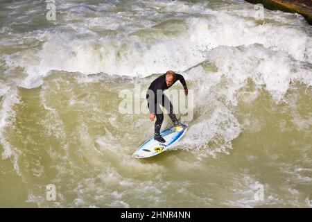 Surfer surft an der Isar in riesigen Wellen Stockfoto