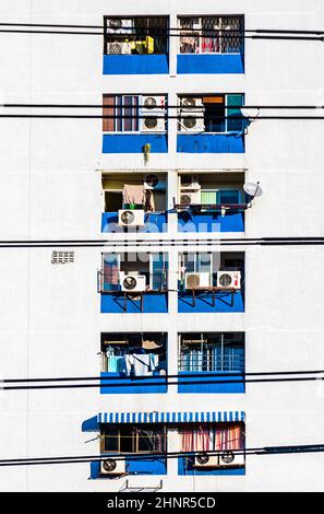 Fassade des Wolkenkratzers mit Wohnungen in Bangkok und Balknoien mit Kleidung zum Trocknen Stockfoto