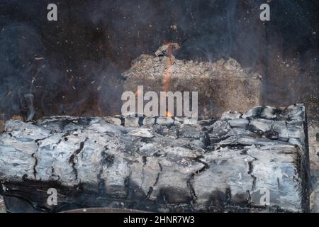 Brennendes Brennholz mit Rauch aus nächster Nähe. Brennendes Holzholz im Kamin Stockfoto
