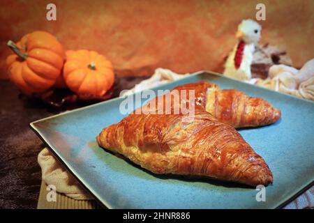 Zwei Croissants auf dem Teller mit Danksageböten. Stockfoto