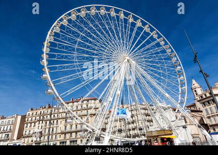 Die Menschen genießen in Marseille ein großes Riesenrad gegen den blauen Himmel Stockfoto