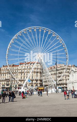 Die Menschen genießen in Marseille ein großes Riesenrad gegen den blauen Himmel Stockfoto