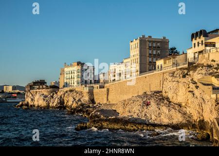 Die Menschen genießen den Sonnenuntergang an der Corniche Kennedy in Marseille Stockfoto