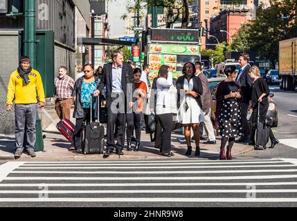 Menschen in der Nähe der Wall Street in Manhattan überqueren die Straße an der weißen Ampel Stockfoto