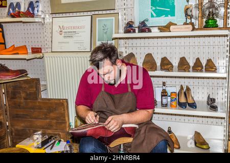 Der Schuhmacher eröffnet seinen Laden auf der jährlichen Bahnhofsviertelsfeier, um sein Handwerk zu zeigen Stockfoto