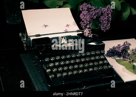 Alte Schreibmaschine, Blatt Papier und Flieder Stockfoto