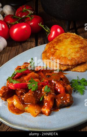 Original ungarischer Gulasch mit Kartoffelpfannkuchen Stockfoto